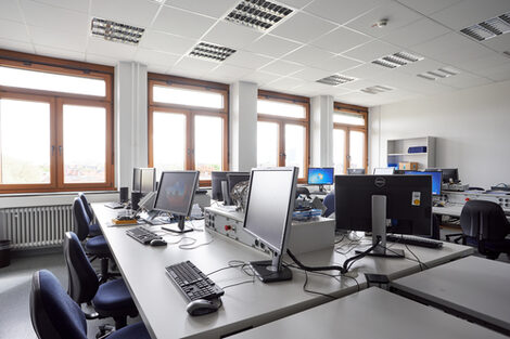 Photograph of a laboratory for embedded systems with several workstations. Each workstation is equipped with a PC.