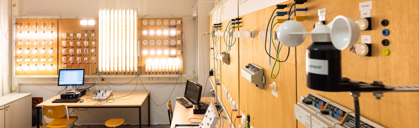 Ein Foto vom Labor für elektrische Gebäudesystemtechnik. An der Wand kann man eine Beleuchtungsanlage erkennen.