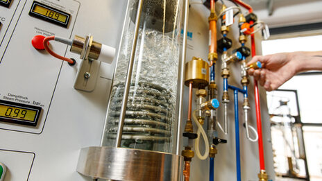 Foto eines Versuchsaufbaus im Labor für Energietechnik und Wärmeübertragung, unter anderem bestehend aus einer Glassäule, in der Wasser erhitzt wird.