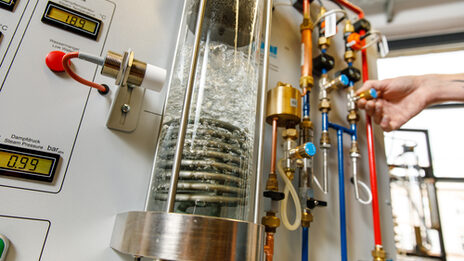 Photo of an experimental set-up in the laboratory for energy technology and heat transfer, including a glass column in which water is heated.