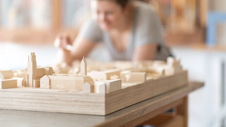 Nahaufnahme von einem Städtebaumodell mit Studentin in der Modellbauwerkstatt<br>im Fachbereich Architektur