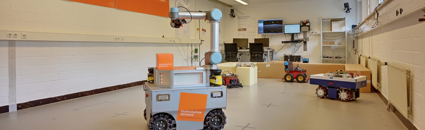 Mobile robots and manipulators of the robot laboratory in the laboratory__Arrangement of five mobile robots in the robot lab with workstations and screens