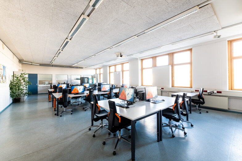 Room shot of the laboratory for networks and operating systems, with several rows or groups of tables equipped with computers.