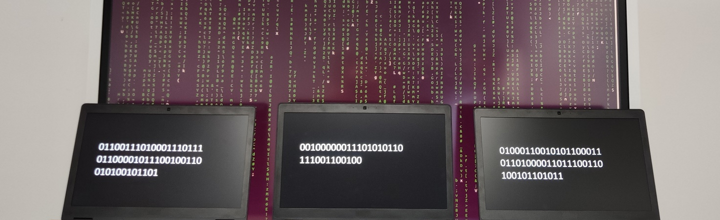 Three laptops standing next to each other with numeric codes, behind them a large screen with many characters one below the other.