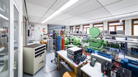 Raumaufnahme des Labors für Leistungselektronik und Antriebssysteme mit vielfältiger Laborausstattung und vielen Geräten und Maschinen.