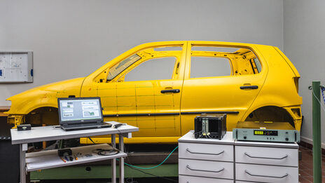 Photo of a partial room recording with various setups for vibration and acoustic measurements.