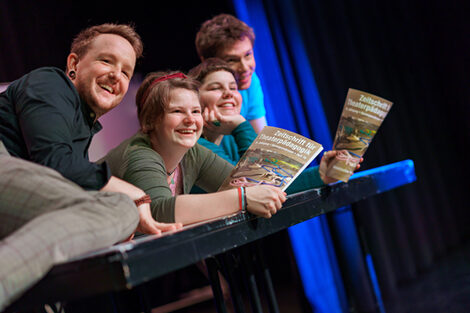 Photo of laughing actors at a rehearsal in the theater lab.