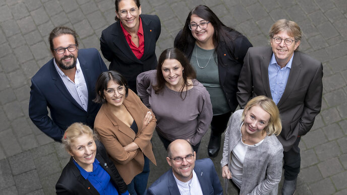 Photo of several people looking up at the camera and smiling.