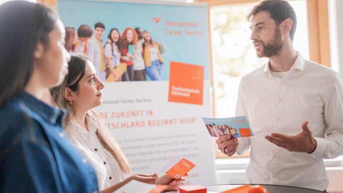 Jan Schmieder from the International Career Service counseling international students at a bar table.