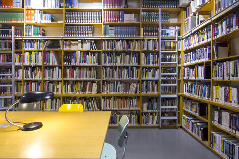 Photo of the library reading room with book shelves, desks, reading lamps and chairs__Photo of the library reading room with book shelves, desks, reading lamps and chairs