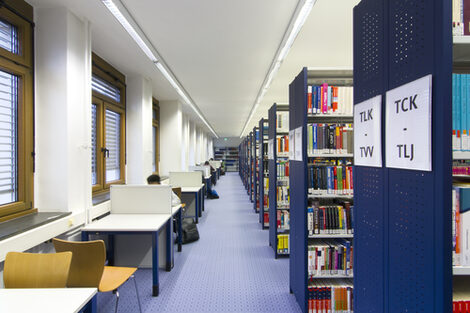 Foto von Bücherregalreihen und Einzelarbeitsplätzen in der Bibliothek__Photo of library book shelves and desks