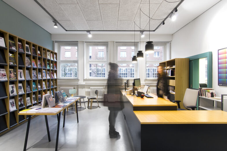 Foto einer Studierenden im Gespräch mit einer Mitarbeiterin der Bibliothek an der Ausleihtheke__Photo of a female student in conversation with a female member of library staff at the service counter