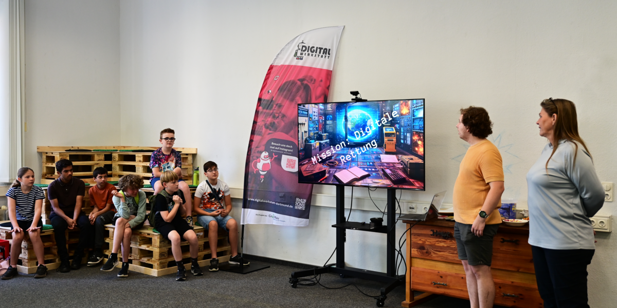 Seven students on the left of the picture listen to Sabine Sachweh and Marcel Mitas describing the "Digital Rescue" escape room.