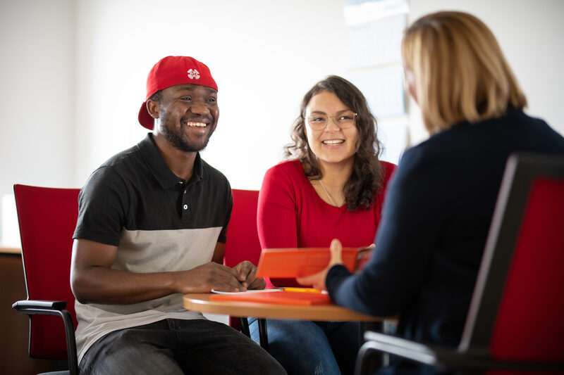 Photo of two international students during a counseling session with an employee of the International Office.