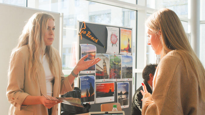 Two young women chat in the sunshine at an international trade fair stand at the "Marketplace of Opportunities"__Two young women chat in the sunshine at an international trade fair stand at the "Marketplace of Opportunities"