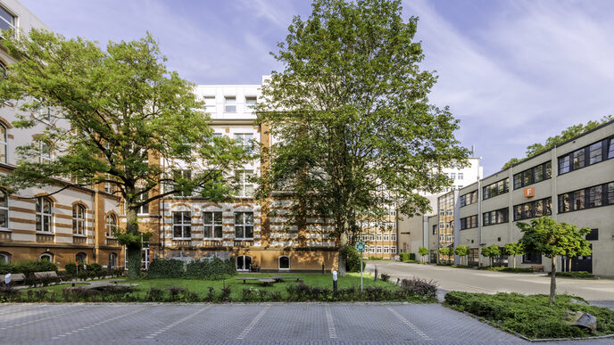 Gebäudeaufnahmen an der Sonnenstraße, im Vordergrund Parkplätze.