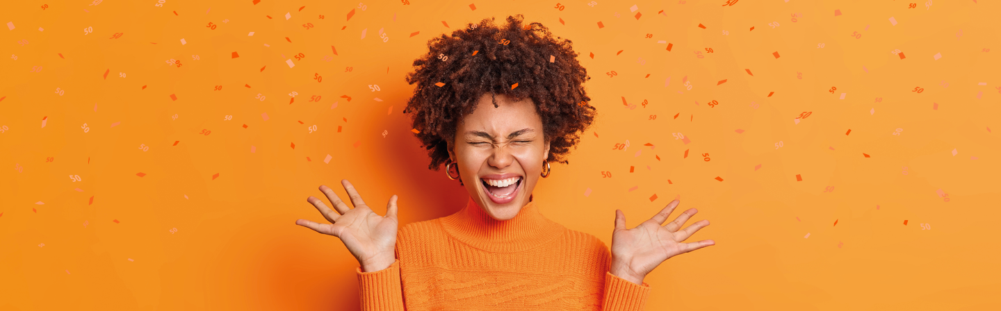 A person read as a female cheers. Confetti falls around her.