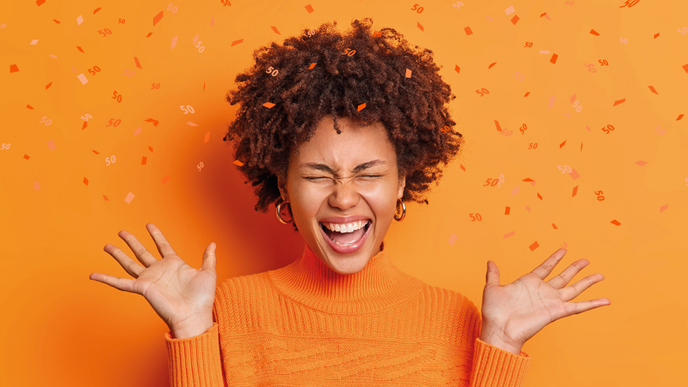 A person read as a female cheers. Confetti falls around her.