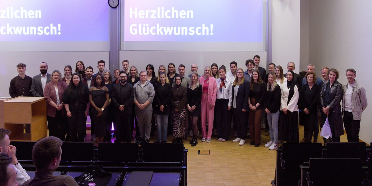 Group photo of the graduates on the stage of the lecture hall.