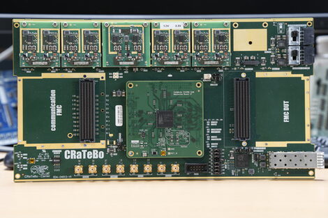 a thin green circuit board with slots and technical components