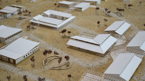 Modellaufsicht mit mehreren eingeschossigen Gebäudemodellen aus weißer Pappe.