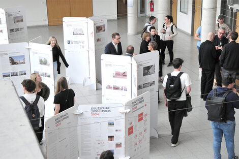 Exhibition in the foyer of the faculty with free-standing white panels presenting architectural projects for the German Brick Award 2024.