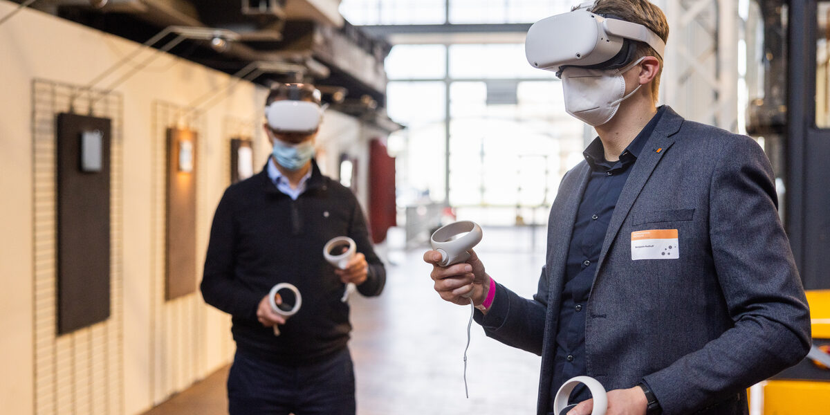 Personen in der DASA tragen beim DART-Symposium 2021 VR-Brillen, um in die virtuelle Welt einzutauchen.