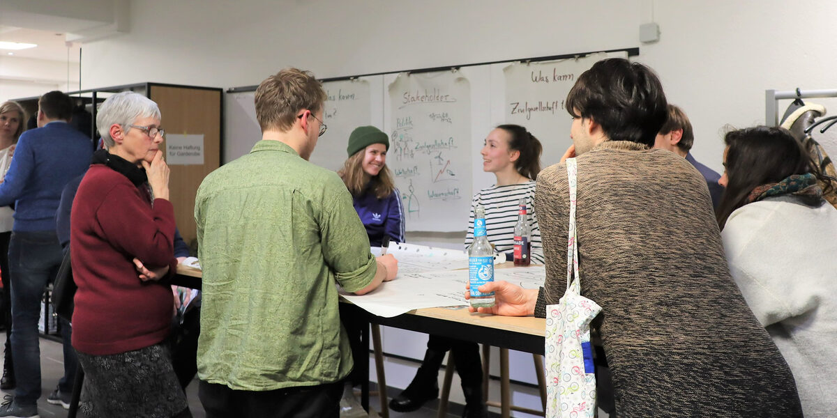 Several people are standing at a table and talking.