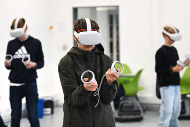 Three teenagers wear VR glasses