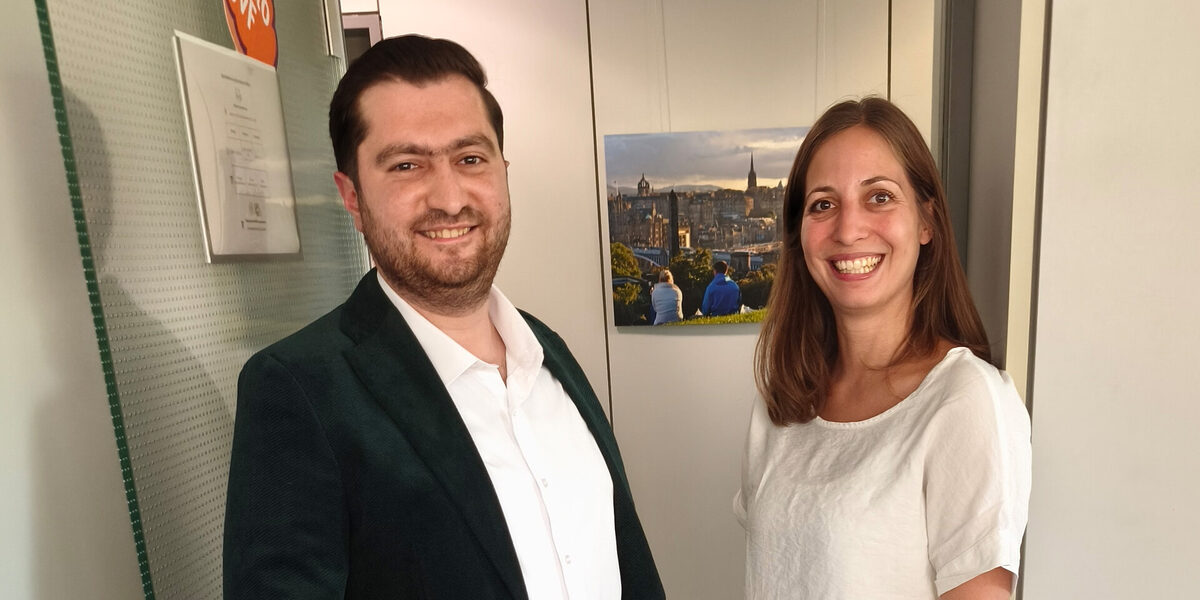 Zwei Personen stehen nebeneinander vor einer geöffneten Tür.