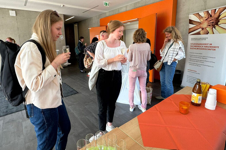Menschen stehen im Foyer vor einem Hörsaal