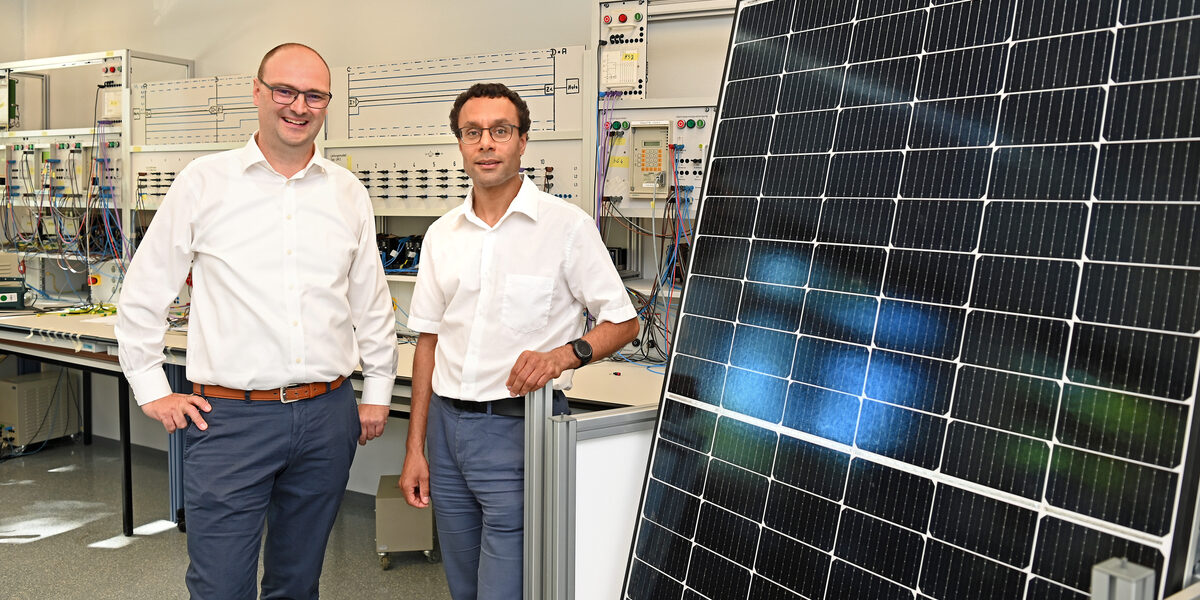 Zwei Personen stehen in einem Labor der FH Dortmund neben einem Solarpanel.