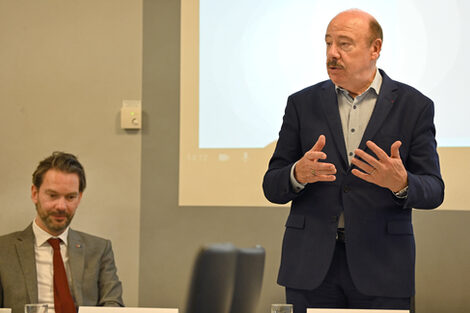 Eine Person steht und spricht.