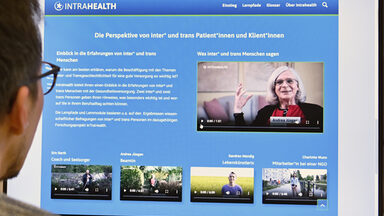 Eine Person schaut auf einen Monitor auf dem die Intrahealth-Website zu sehen ist.