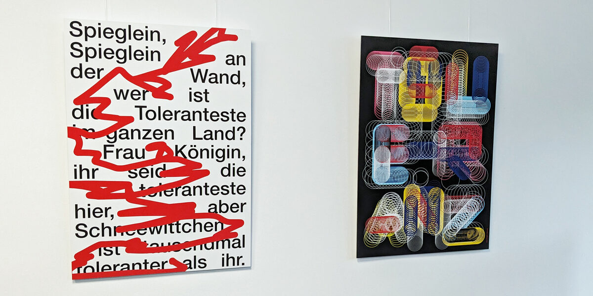 Zwei Plakate zum Thema Toleranz hängen an einer weißen Wand. Das eine Plakat fragt: Spieglein, Spieglein an der Wand, wer ist die tolerantestes im ganzen Land."