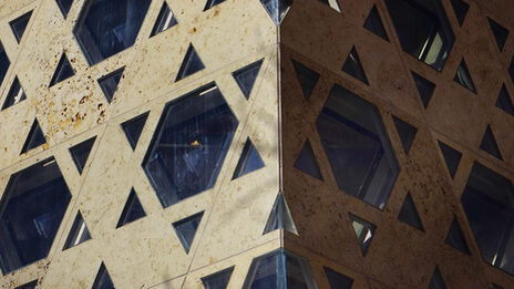 The outer wall of a synagogue with windows in the shape of the Star of David.