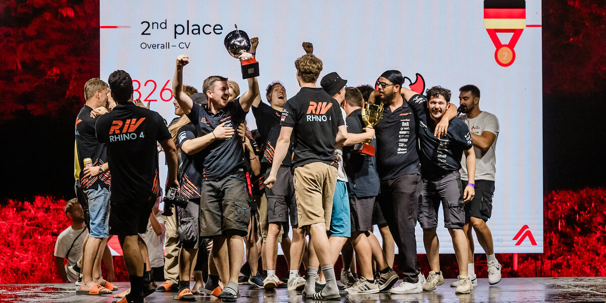 Menschen jubeln und halten Pokale in die Höhe.