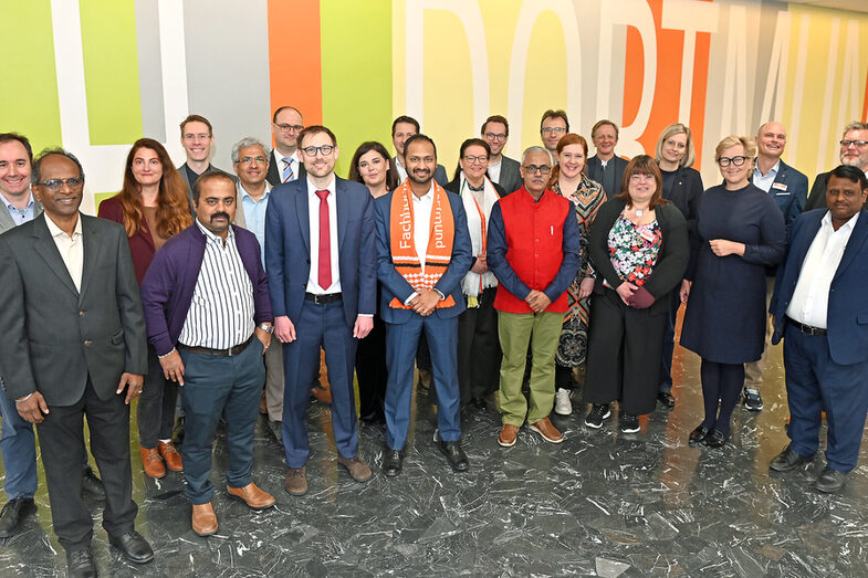 Viele Menschen stehen vor einem Schriftzug "FH Dortmund"