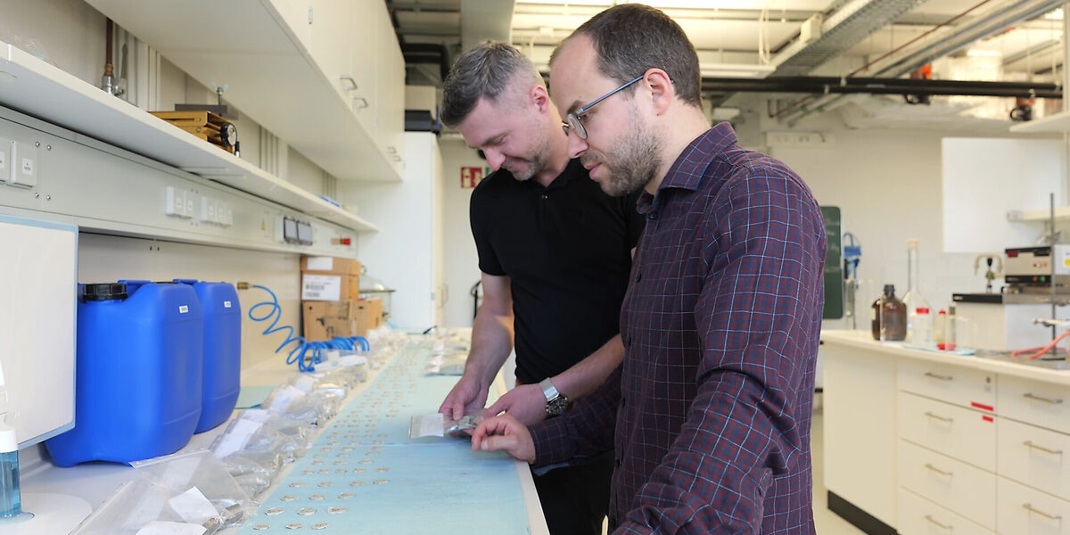 Zwei Personen stehen in einem Labor und untersuchen Proben.
