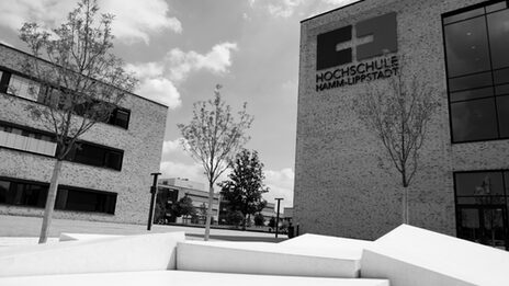 Gebäude auf einem der Schriftzug Hochschule Hamm-Lippstadt. Das Fotos ist schwarz-weiß.