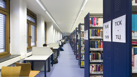 Foto von Bücherregalreihen und Einzelarbeitsplätzen in der Bibliothek__Photo of library book shelves and desks