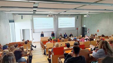 Lecture in lecture hall U33, where the hall is full and Professor Ute Fischer is introducing guests in the foreground
