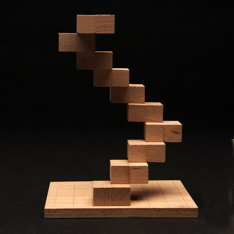 Several wooden blocks on a board are stacked to form a slanted tower