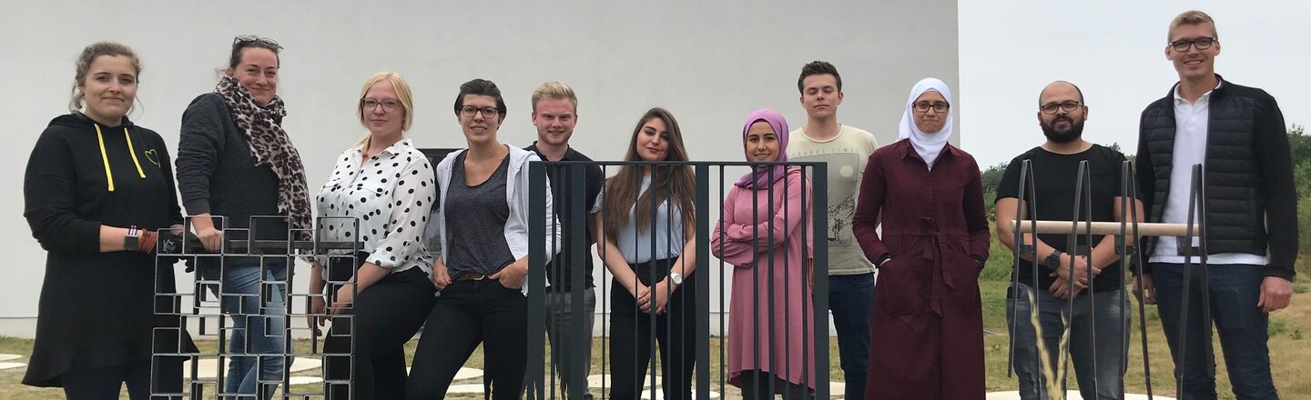 Gruppenfoto der Teilnehmenden Studierenden auf dem Campus mit drei Geländer-Prototypen.