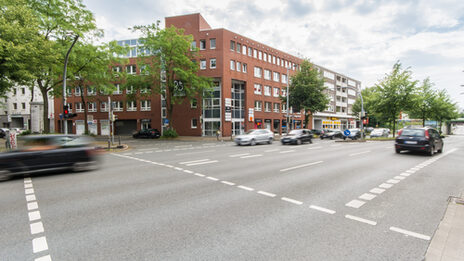 Foto eines Gebäudes an der Hohen Straße in Dortmund, davor die stark befahrene Hohe Straße.