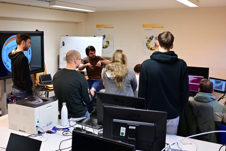 Students are gathered in the IDiAL's student workroom. All eyes are on Alexander Miller, who is gesticulating strongly as he explains the kinematics of the EduRobs.