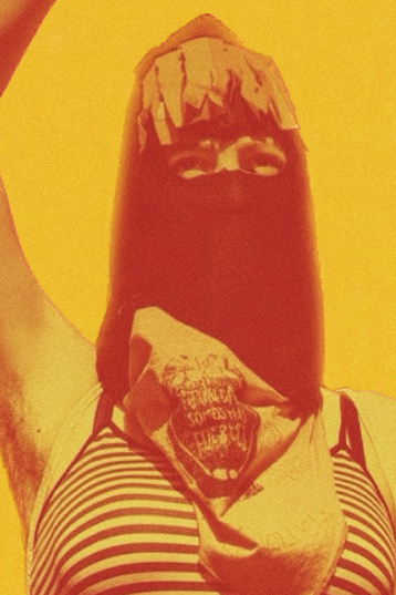 A masked person with his right arm raised.