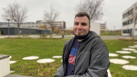 Porträtfoto, das Burak Üyüküler auf dem Campus der Fachhochschule Dortmund zeigt