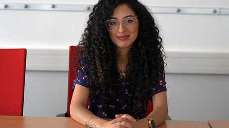 Porträtfoto, das Sedra Dayoub an einem Tisch sitzend zeigt