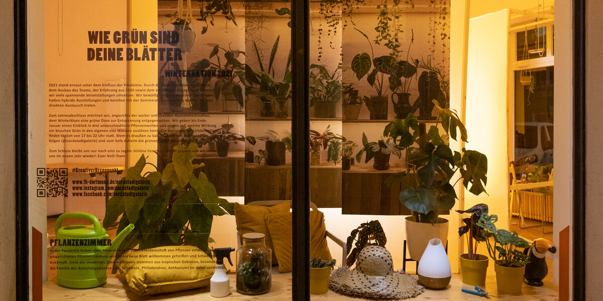 Illuminated window with houseplants and canvases printed with plants.